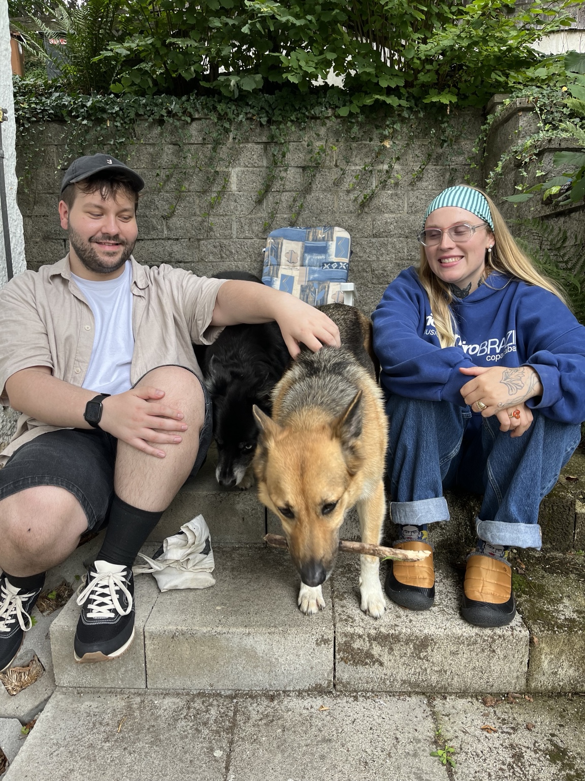 Stefan sitting outdoors with a friend and a dog